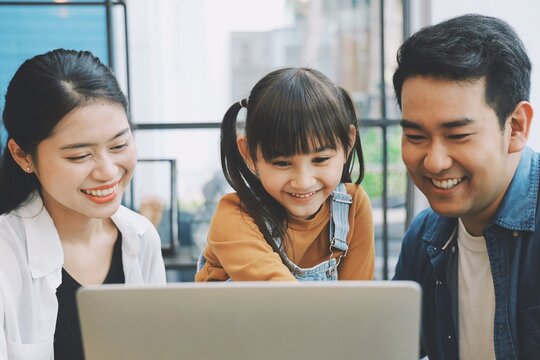 Happy family using laptop together at living room,Parents watching movie with child.