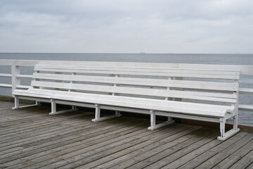 Fototapeta na wymiar Empty bench on wooden boardwalk at seashore