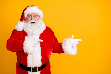 Photo astonished beard santa claus impressed x-mas noel christmas adverts discount point finger copyspace wear cap headwear style stylish trendy costume isolated bright shine color background