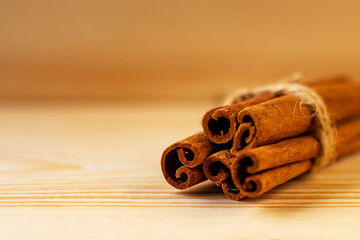 Cinnamon sticks on a wooden background, place for text. Side view. 
