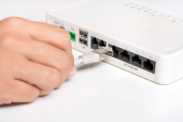 Hand connects network cable in router. Access to internet