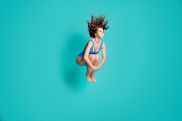 Fototapeta na wymiar Photo of slim thin slender girl rest relax resort jump springboard dive water pool hold breath hands legs wear blue bodysuit isolated over turquoise color background