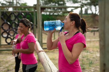 Woman drinking water at boot camp