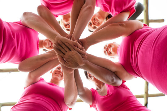 Group of woman stacking hands together at boot camp