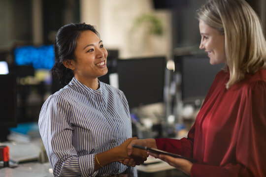 Two businesswoman shaking hands at modern office