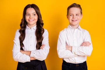 Portrait of her she his he nice attractive cheerful cheery smart clever pupils folded arms new academic year autumn fall season isolated over bright vivid shine vibrant yellow color background