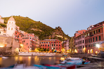 Vernazza town at night, long exposure of the romantic village in CInque terre park at dusk with moving boats