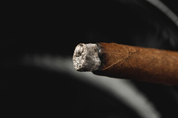Lighted cigar in an ashtray close up