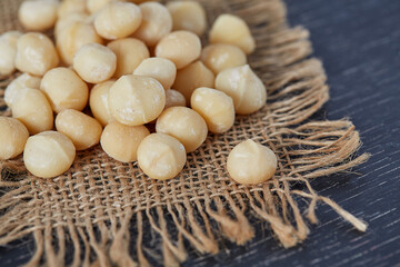 macadamian nuts on dark wooden surface