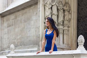 Fototapeta na wymiar Young beautiful stylish girl in blue summer dress walking and posing in an old city center scene in Vienna, Austria