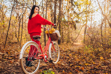 beautiful girl - brunette walks in the autumn forest on a bicycle, golden autumn