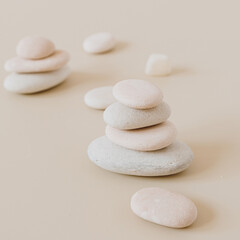 Obraz na płótnie Canvas Pale pastel stones stack on neutral stones. Flat lay, top view minimal spa concept.
