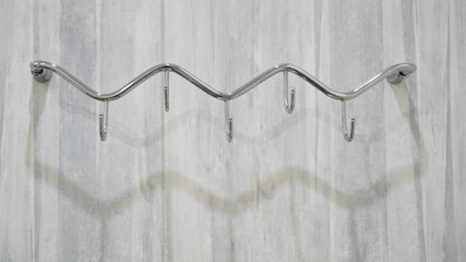 Fototapeta na wymiar Metal adhesive hooks on gray background. Towel hangers