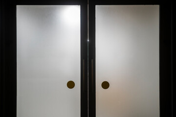 Close up view of steel door handles on glass doors isolated