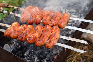 pork sausages strung on skewers cooked on grilled, food cooked outdoors