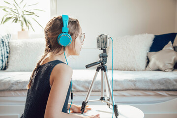 Little girl listening to music and using a cellphone in her room.