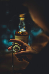 hand holding watch with bottle