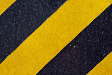 Metallic surface painted with black and yellow stripes