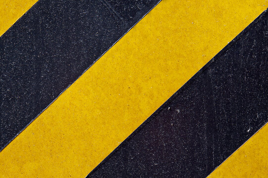 Metallic surface painted with black and yellow stripes © Wagner Campelo