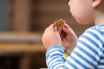 Child eating a cookie wearing a striped sweater