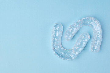 Removable teeth aligners on the blue background with copy space. Orthodontic treatment for beautiful smile.
