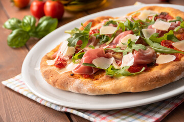 Deliziosa pizza con prosciutto crudo di Parma, rucola e scaglie di formaggio grana, Cucina Italiana