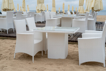 Empty beach chair and table on sandy beach