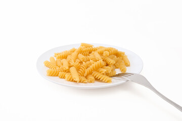 Raw uncoocked pasta fusilli in white ceramic plate with a folk isolated on white, italian cousine concept