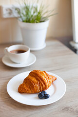 composition with a cup of coffee and a croissant on the table on the Place for the text