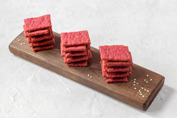 Natural crackers or beetroot cookies on a light background. Healthy food concept for wellness. Diet foods.