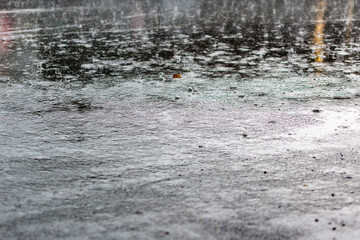 flooded road during heavy rain. raindrops splashes background.