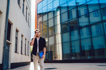 Cheerful businessman talking on smartphone on street