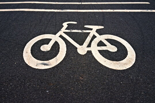 Urban bike path icon on dark asphalt.