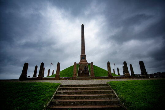 Man with his dog walking upt to the Haraldshaug monument, the burial place of a Viking king