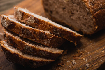 close up view of fresh baked bread slices on wooden cutting board