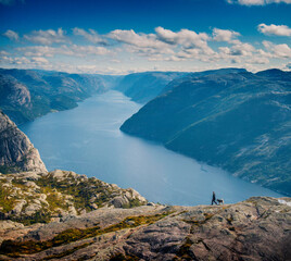Wonderful fjord landscape in Norway, man hiking with his dog
