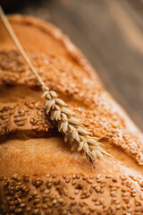 close up view of fresh baked white bread loaf with spikelet