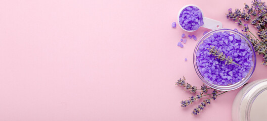 Lavender violet sea salt with lavender flowers, candle. Lavender bath products Aromatherapy treatment on pink color background. Skincare spa beauty bath cosmetic products for relax.Long web banner