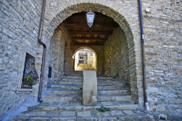Fototapeta premium A narrow street among the old houses of Guardia Perticara, a rural village in the Basilicata region, Italy.