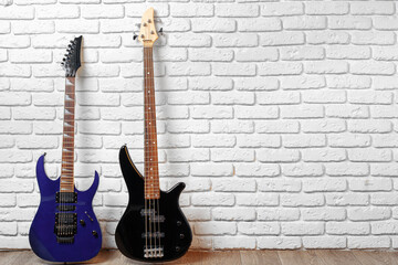Naklejka premium Set of guitars on the floor against white brick wall