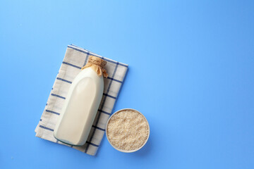 Rice vegan milk in glass bottle on blue background