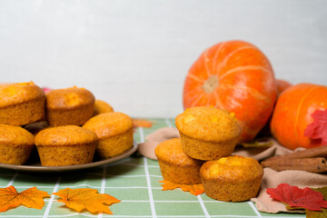 autumn baking pumpkin cupcakes with fresh seasonal pumpkin and cinnamon spices. from the top view . autumn composition with pumpkins and yellow leaves