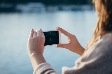 Unrecognizable woman taking photo with her phone outdoor