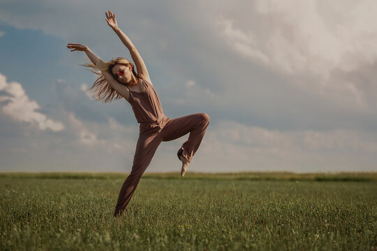girl dancing on a green field