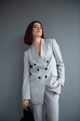 Beautiful fashion woman. Full length portrait of beautiful girl wearing light gray suit and black...