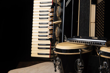 Old accordion, harmonica and bong on rustic wooden surface with black background and Low key...