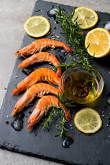 Shrimps on stone background. Grilled prawns with rosemary and lemon. 