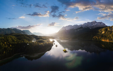 Aerial panorama of Eibsee mountain lake with small islands in the morning sun