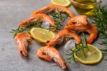 Shrimps on stone background. Grilled prawns with rosemary and lemon. 