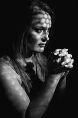 Beautiful woman confesses in the confessional, black and white. Praying woman, fine art portrait...